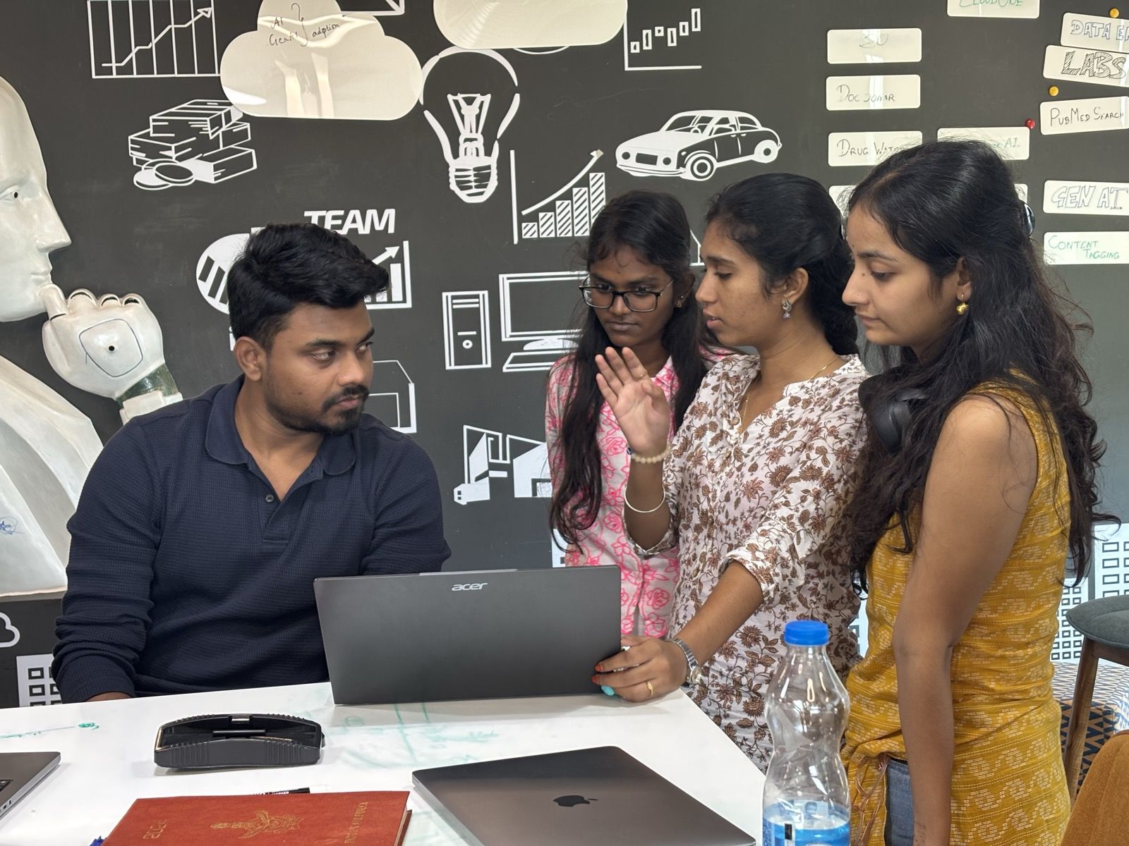 A team working through a problem at a laptop