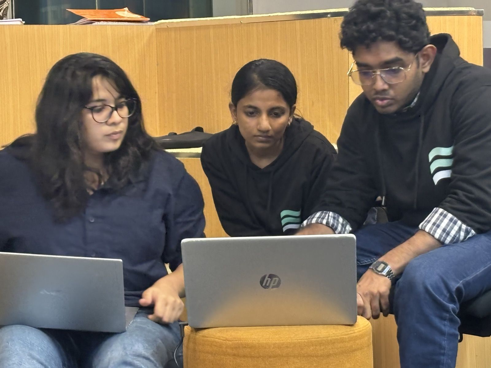 Three students working on one laptop